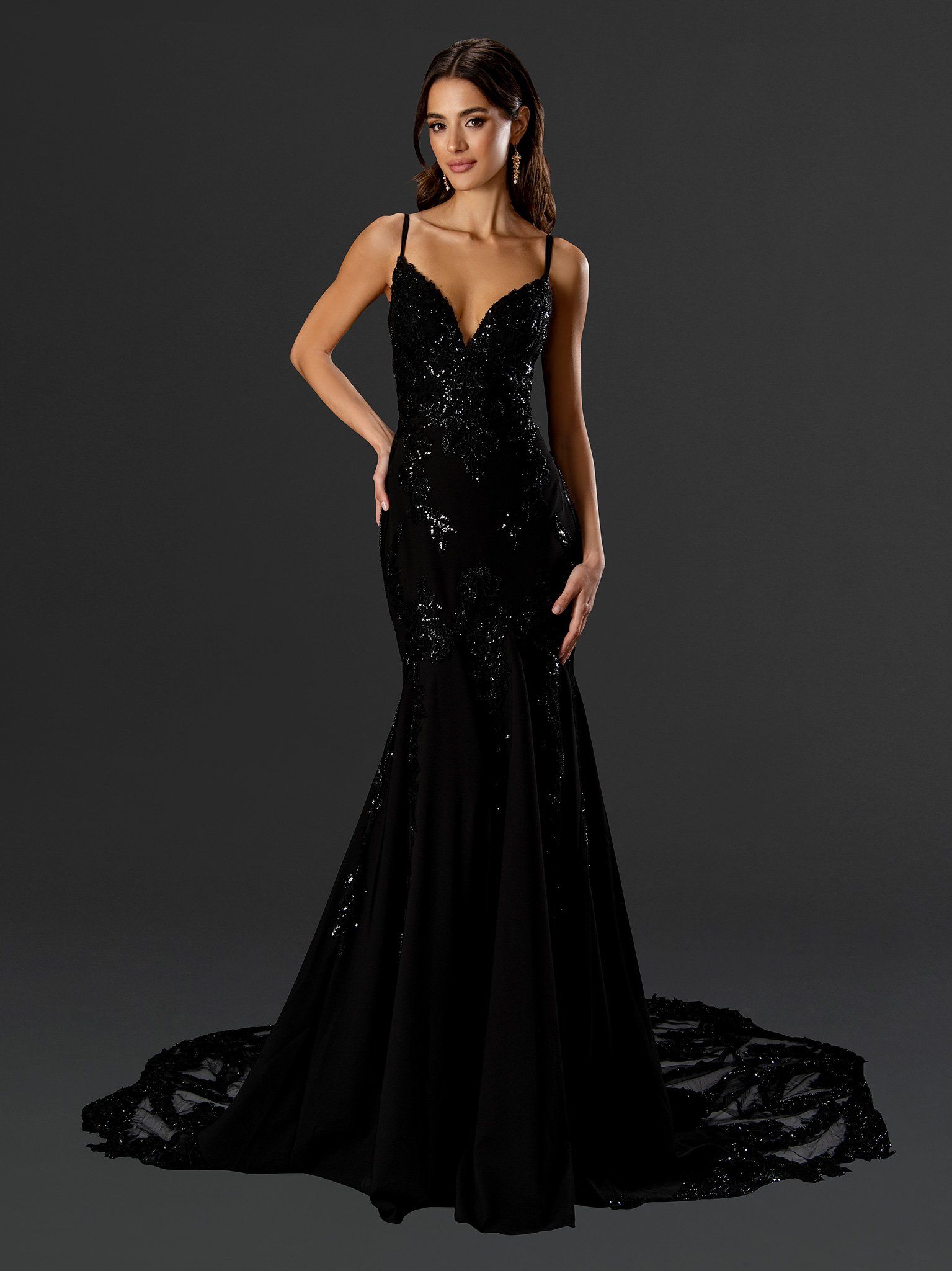 A woman is wearing a long black dress with sequins on it.
