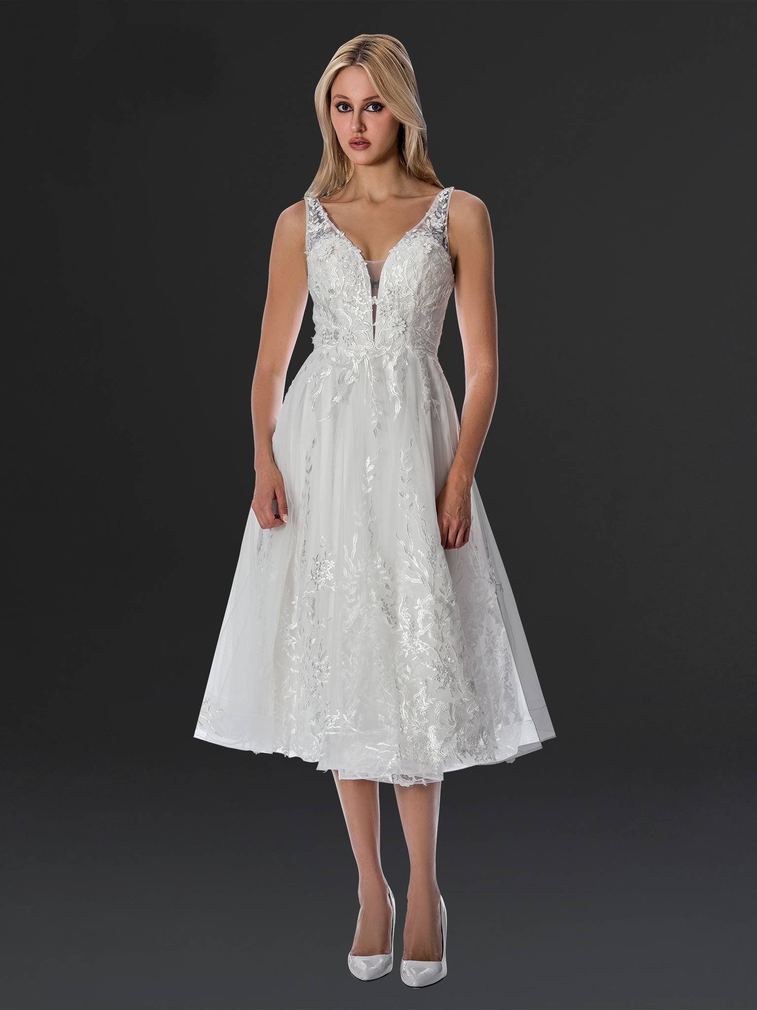 A woman in a white dress is standing in front of a black background