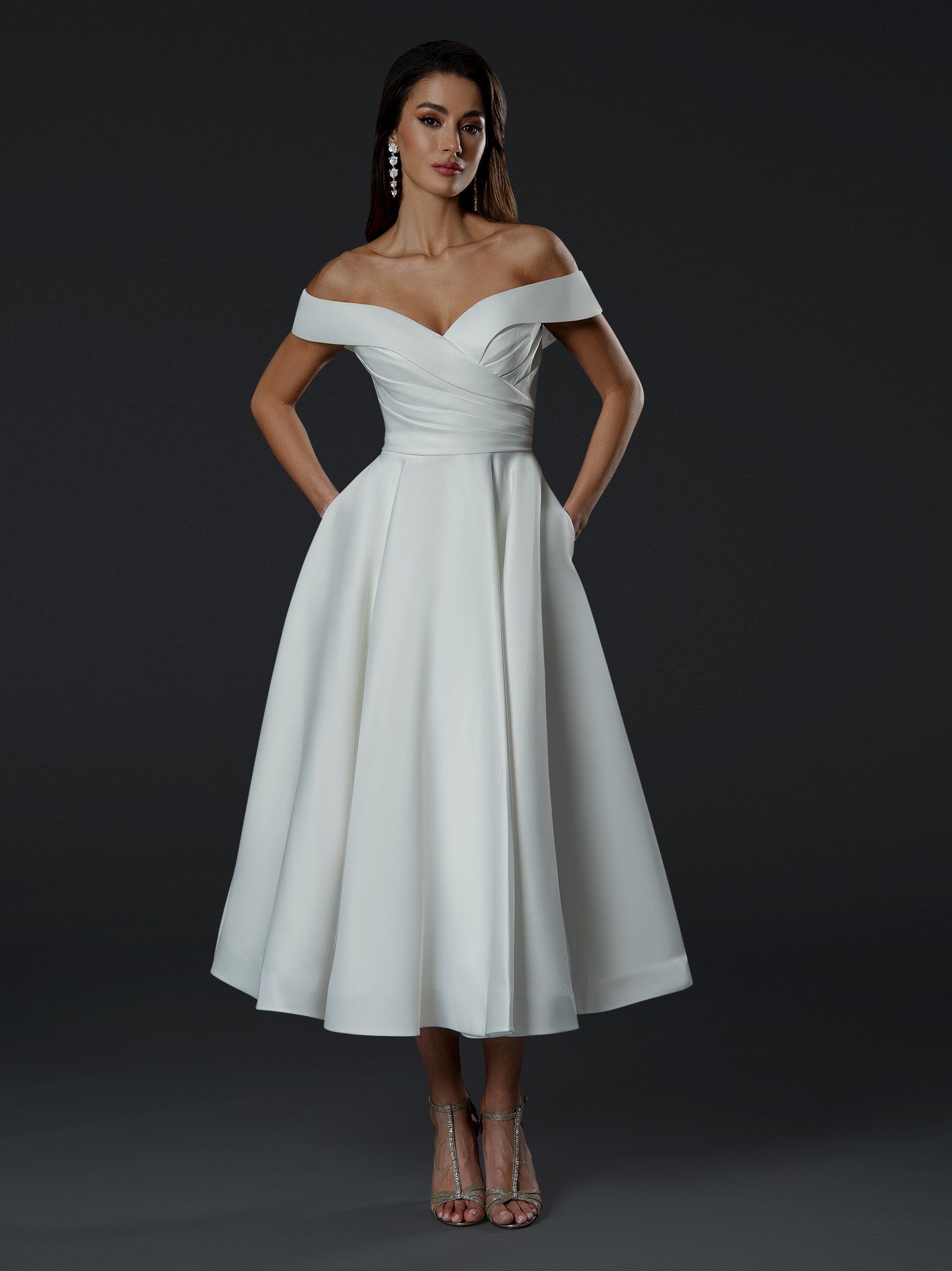 A woman is wearing a white off the shoulder dress