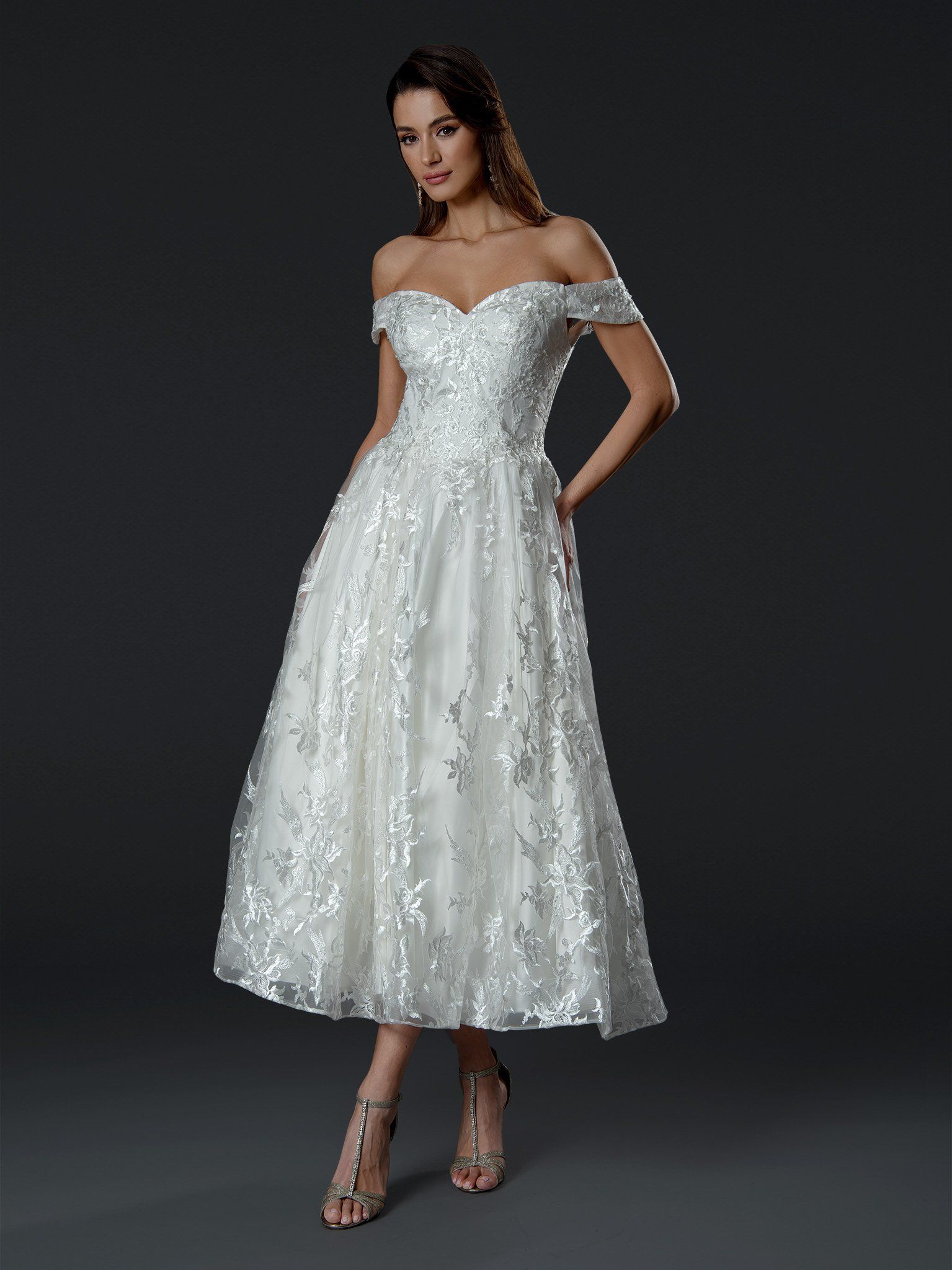 A woman is wearing a white off the shoulder dress