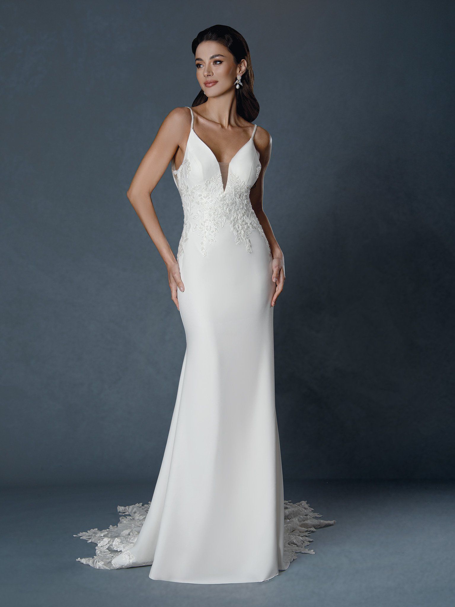 A woman is wearing a white wedding dress with a plunging neckline.