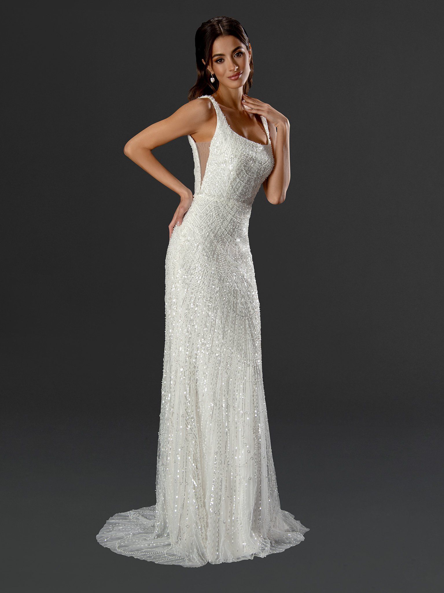 A woman in a white dress is standing in front of a black background