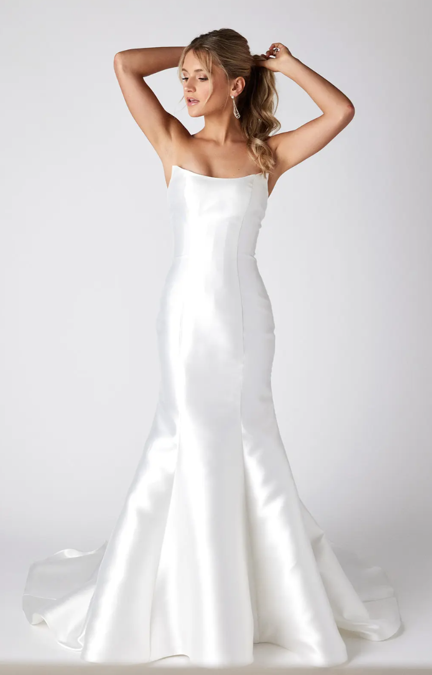 A woman in a white wedding dress is standing on a white background