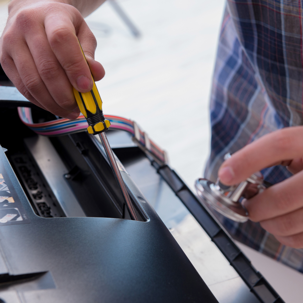 A man is working on a computer with a yellow screwdriver