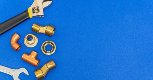 Tools and plumbing parts on a blue surface, with ALPRO logo in the top right corner.