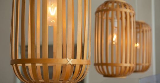 Three bamboo pendant lights with visible light bulbs, hanging indoors.