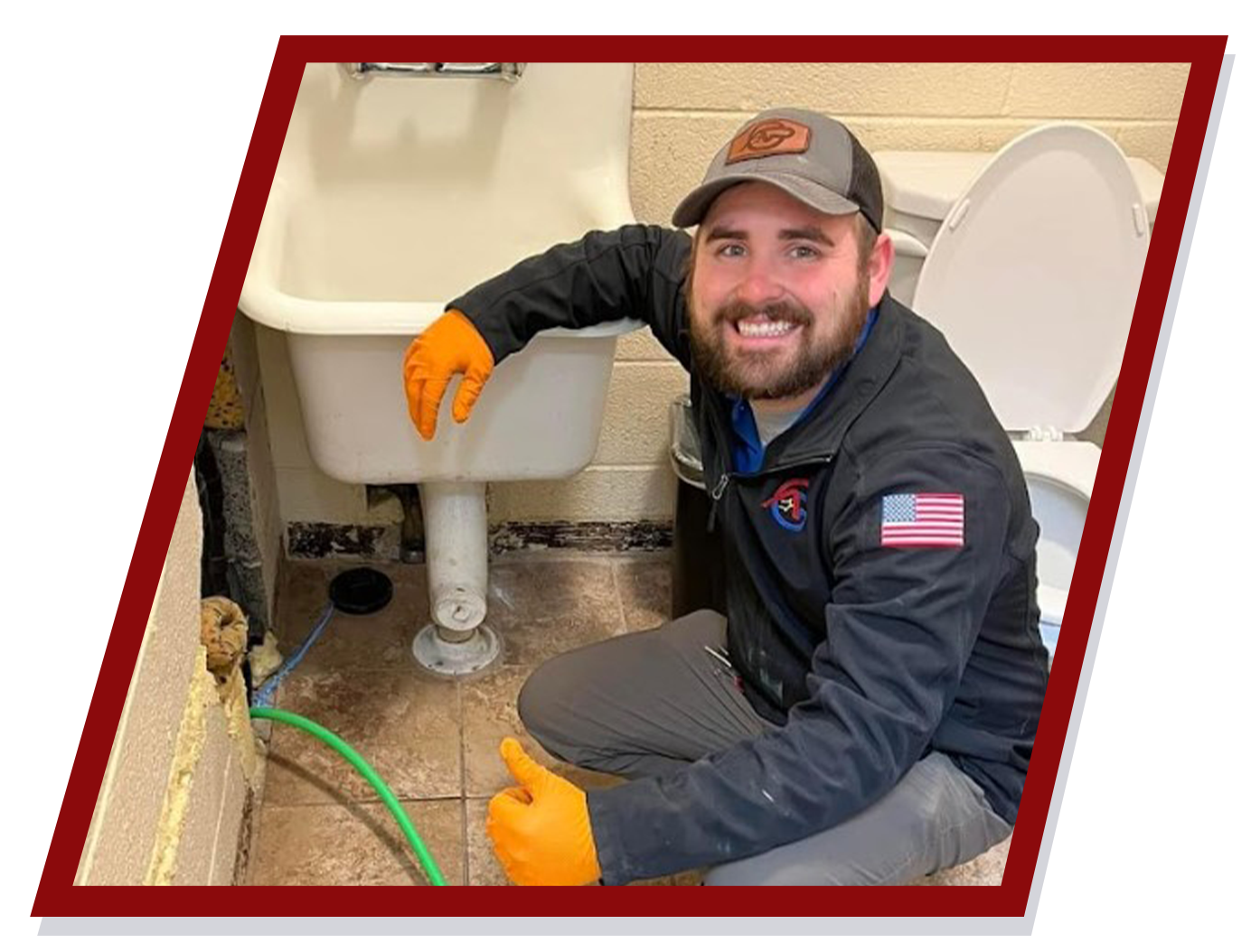 Smiling plumber in bathroom, kneeling by sink, wearing gloves, thumbs up. Smiling plumber in bathroom, kneeling by sink, wearing gloves, thumbs up.