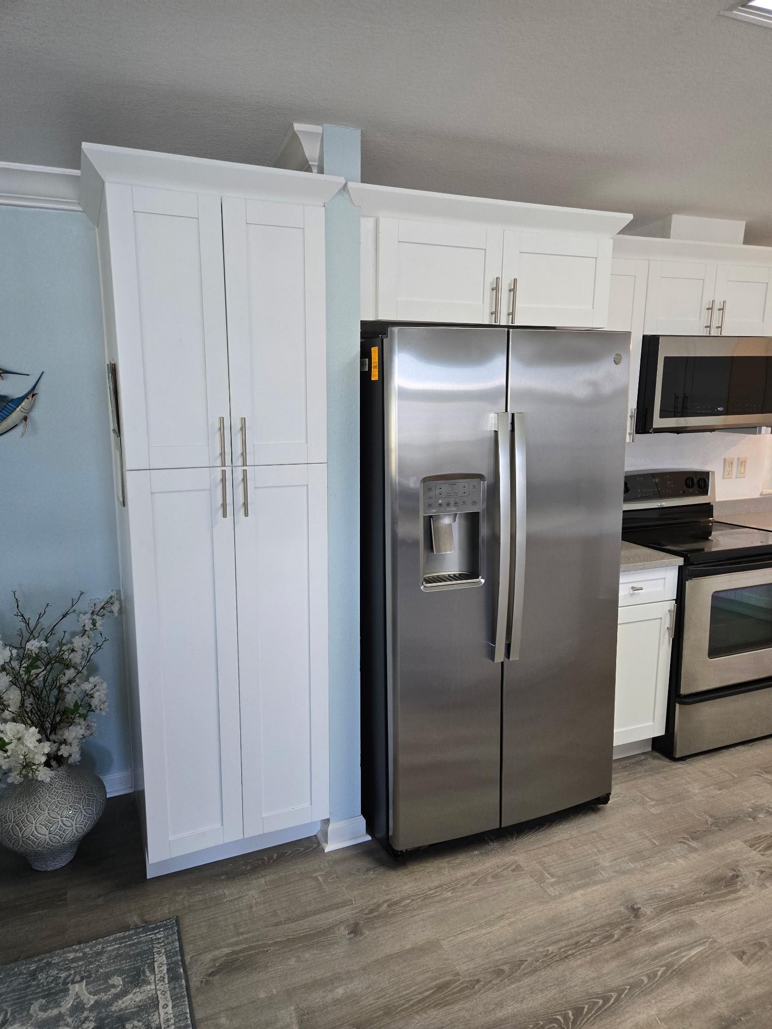 White cabinets and stainless steel fridge in a kitchen.