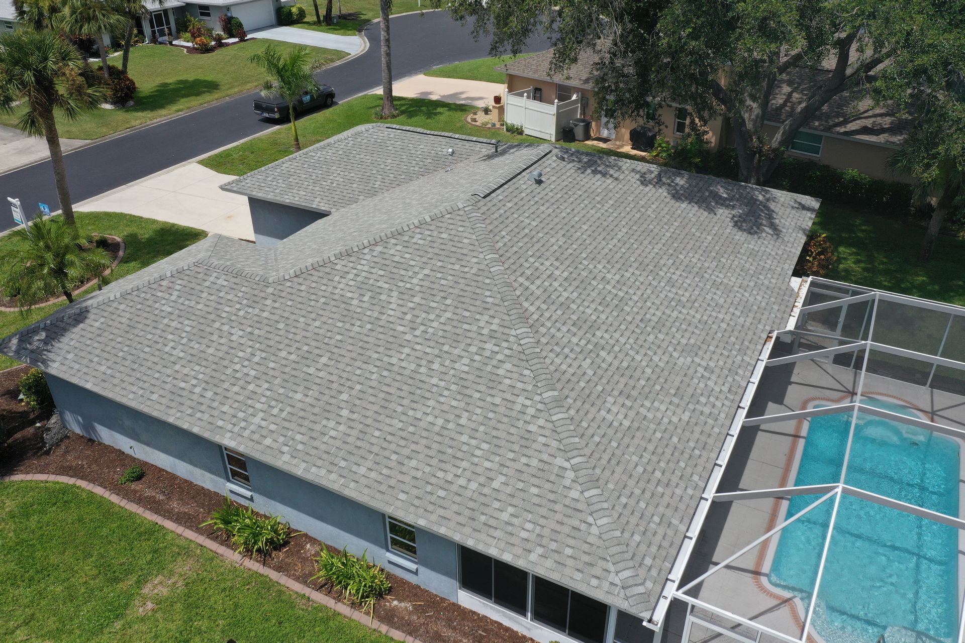 Gray asphalt shingle roof on a single-story house with a pool.