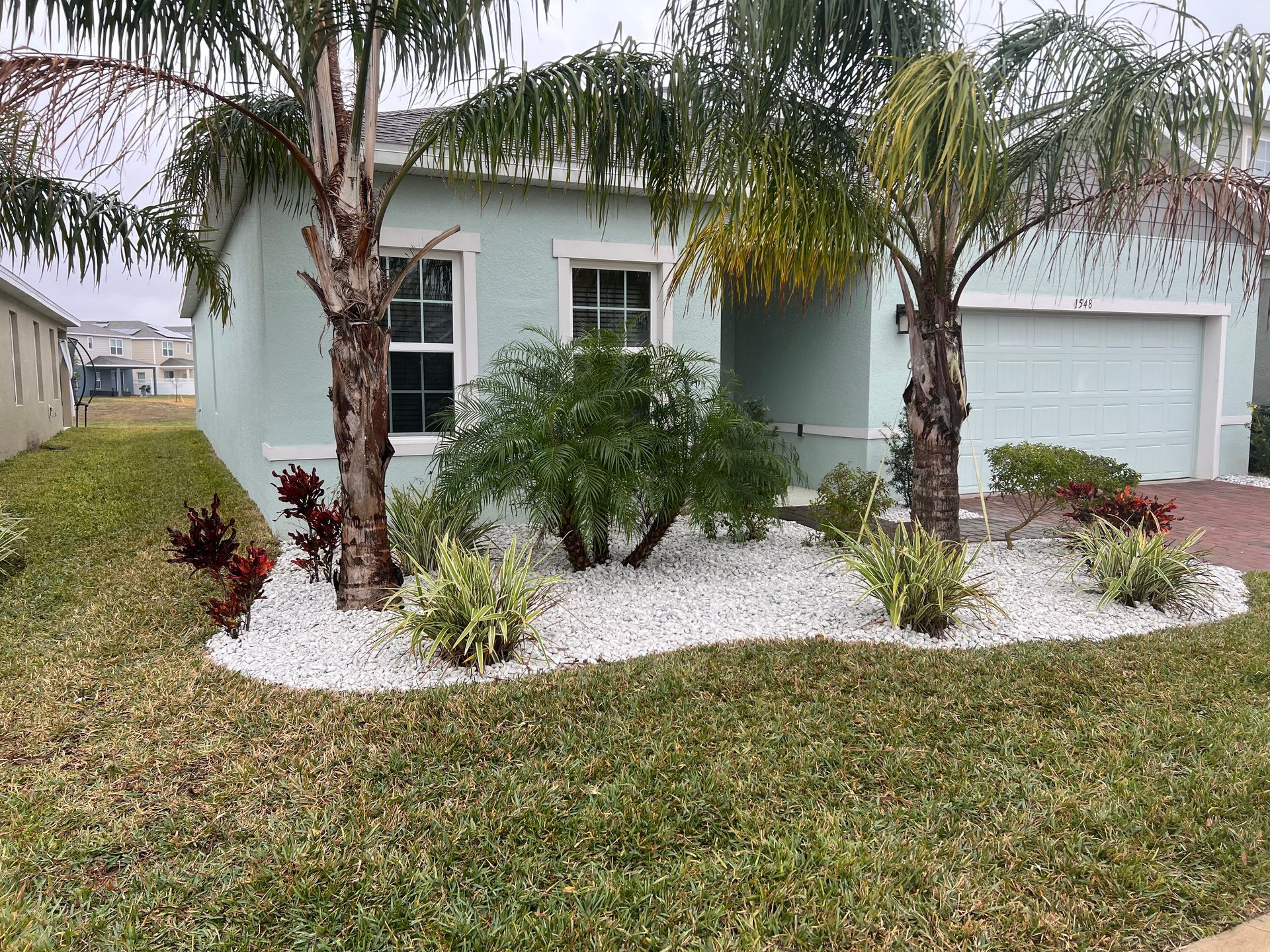 A house with two palm trees in front of it.