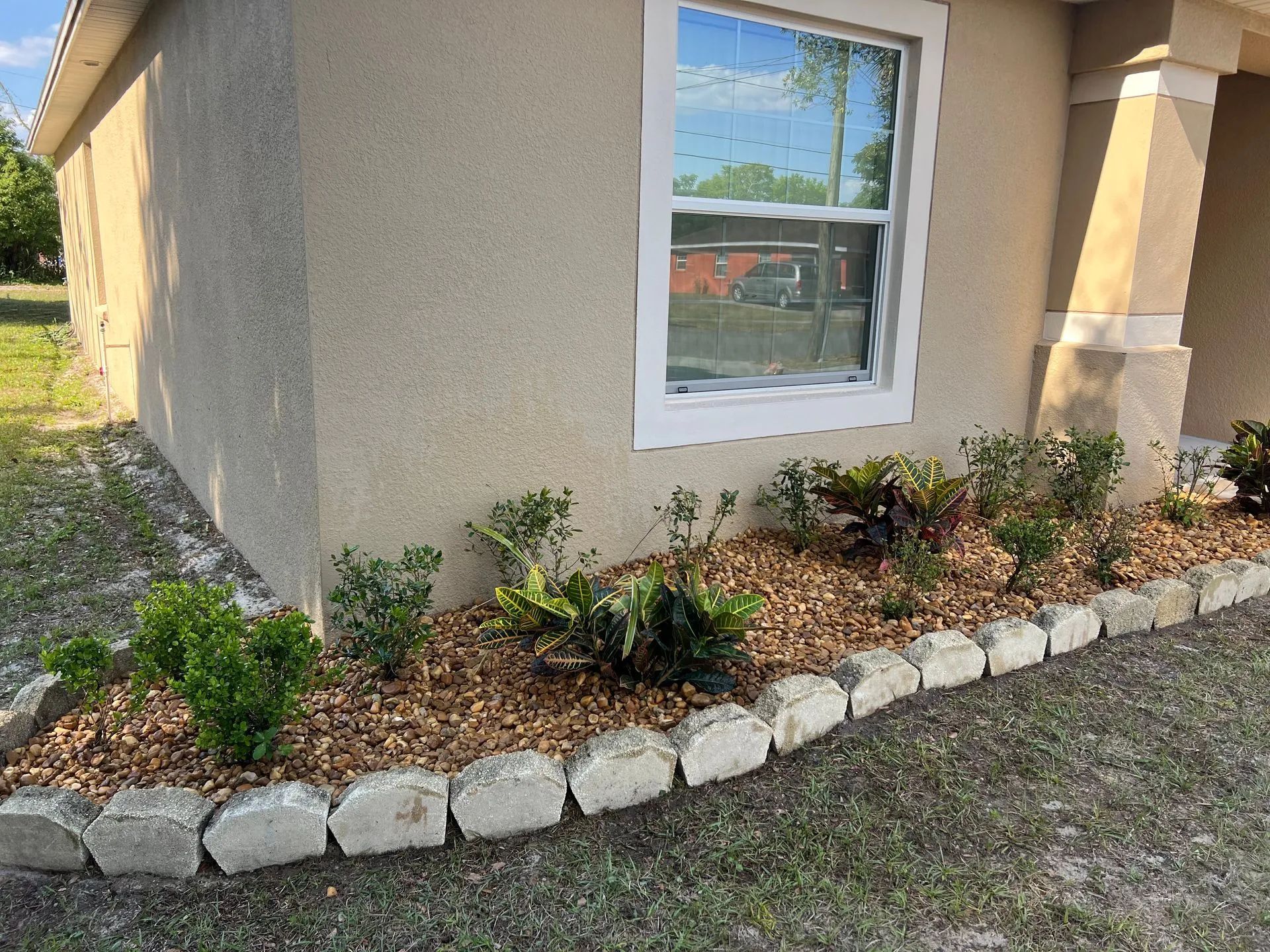 A house with a garden in front of it and a window.