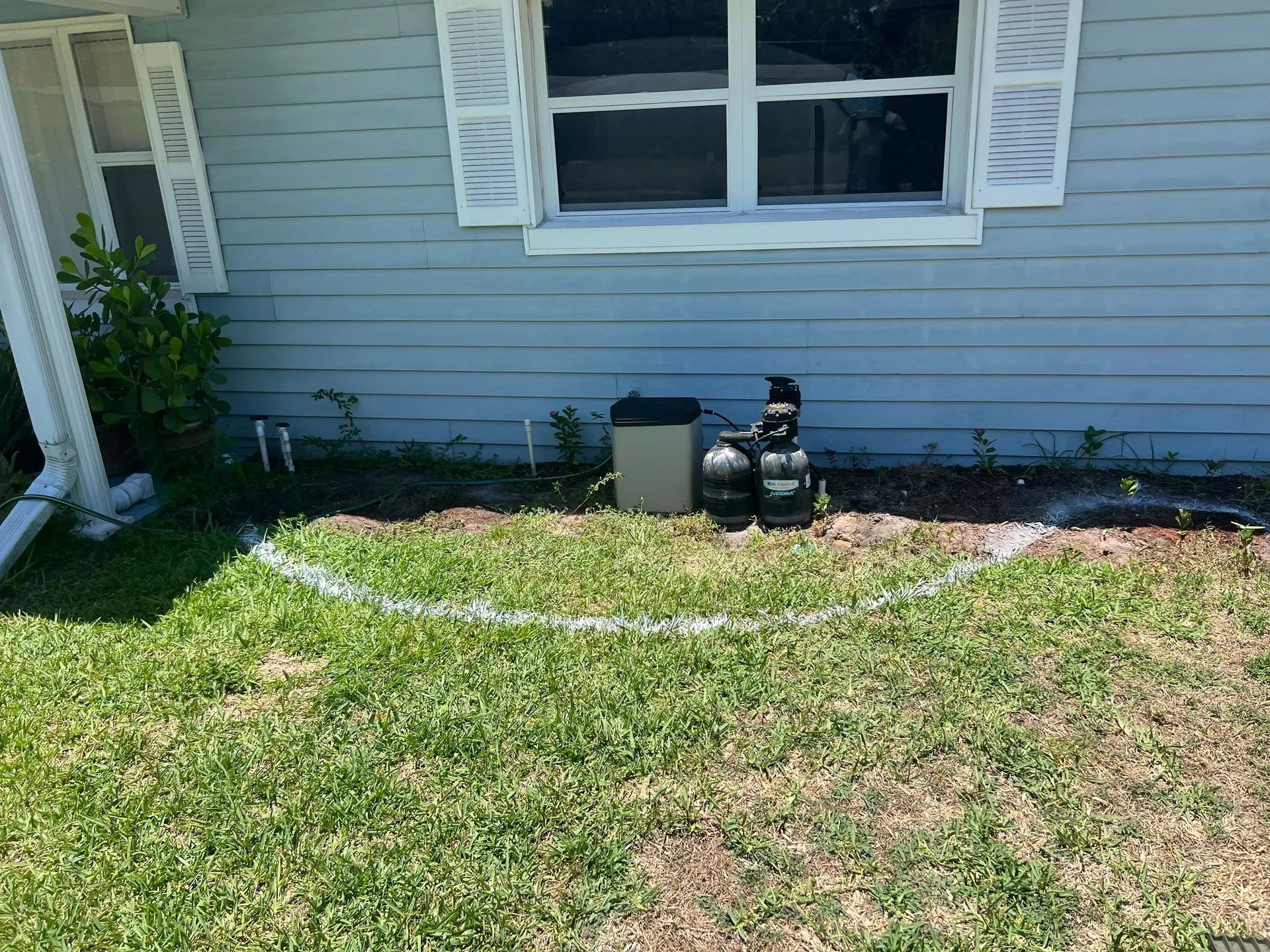 A house with a circle drawn in the grass in front of it.