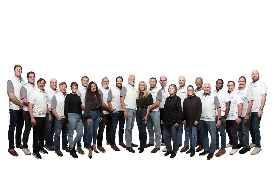 Group of people in white shirts and jeans, posing against a white background.