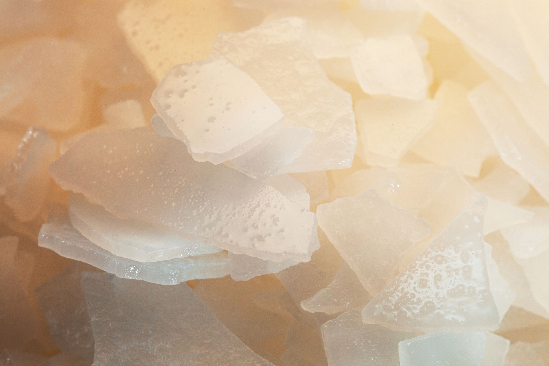 Close-up of translucent, irregular, pale-yellow flakes.