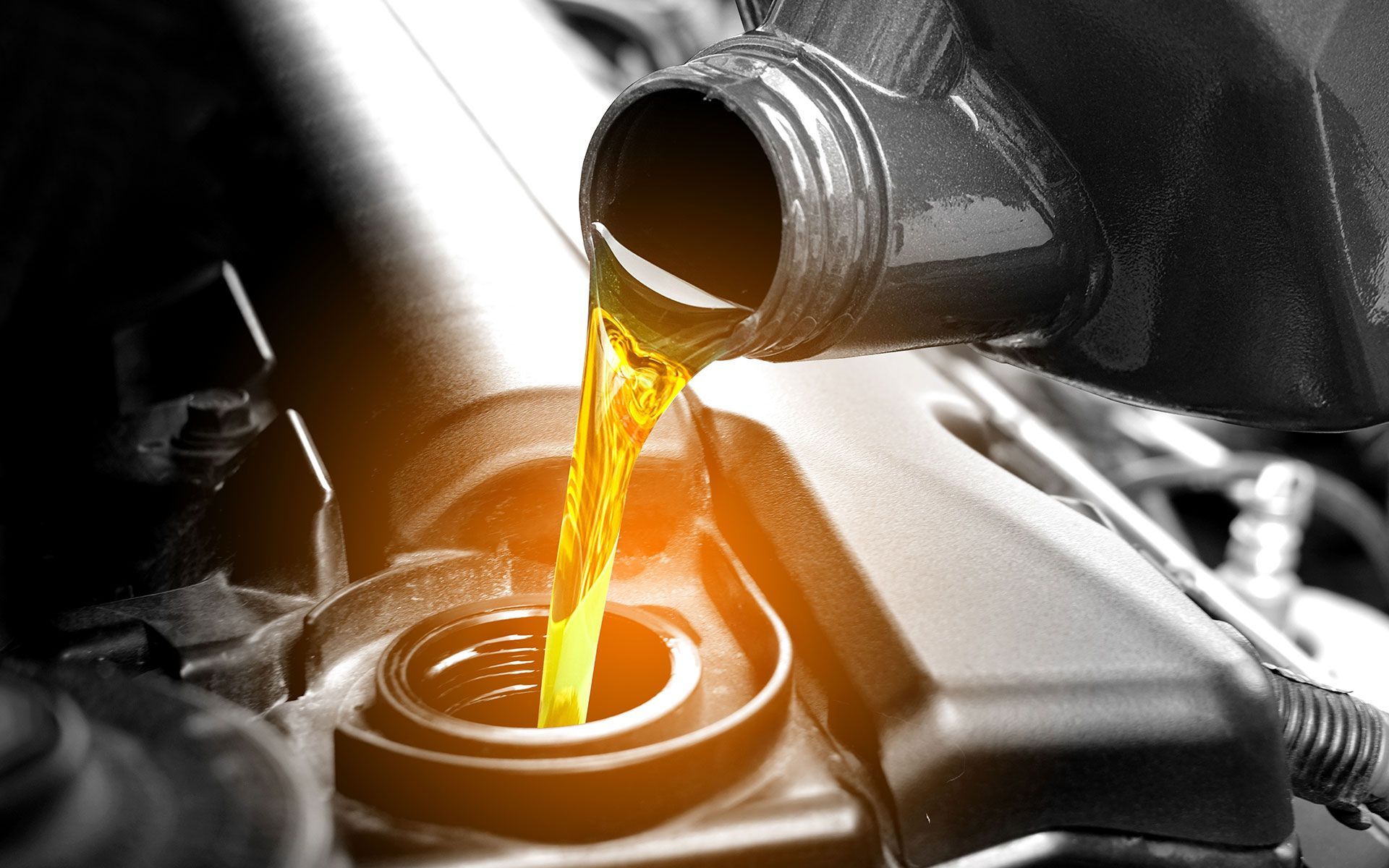 Oil being poured into a car engine.