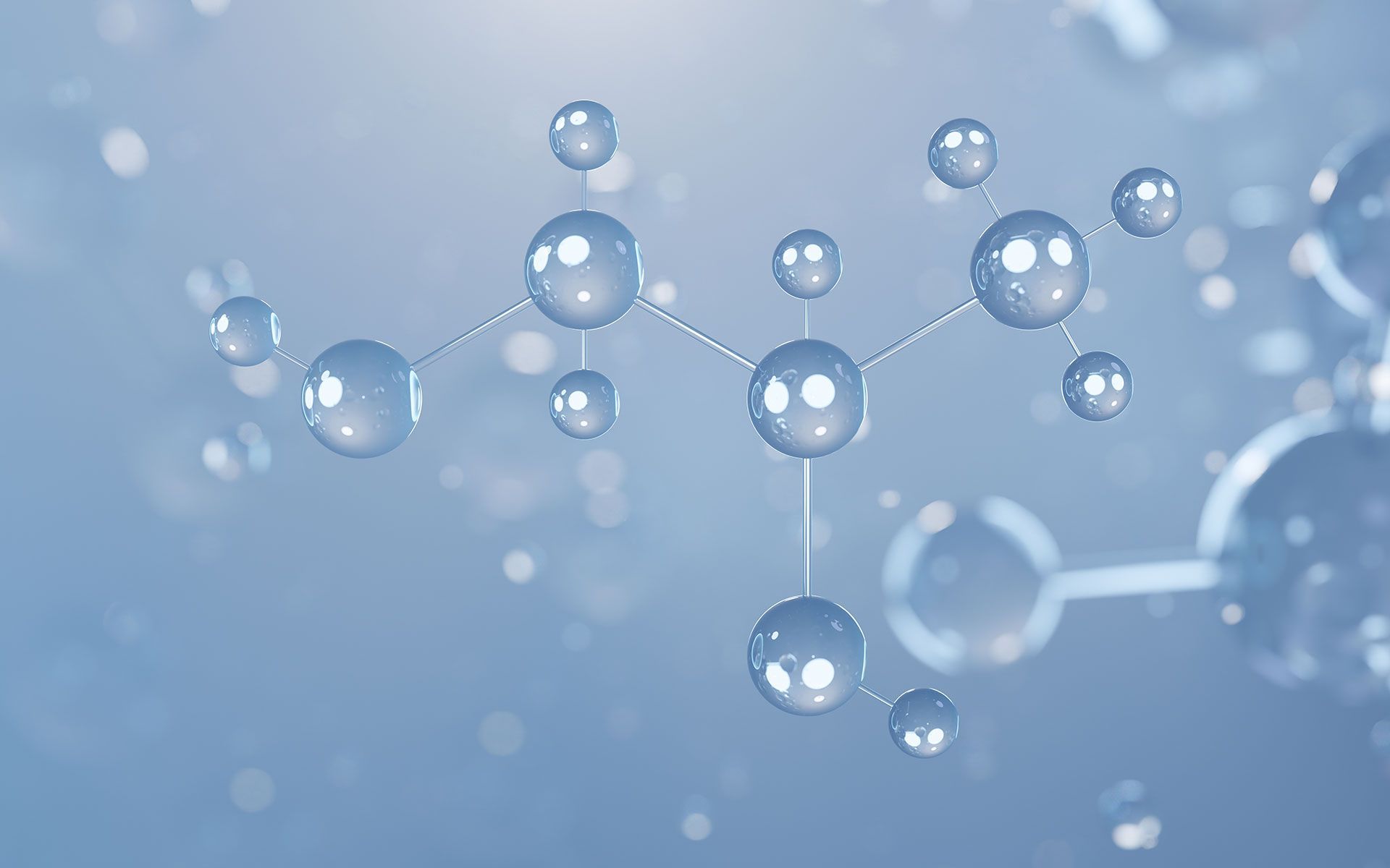 Molecular structure model with translucent spheres and connecting lines, against a blurry blue background.