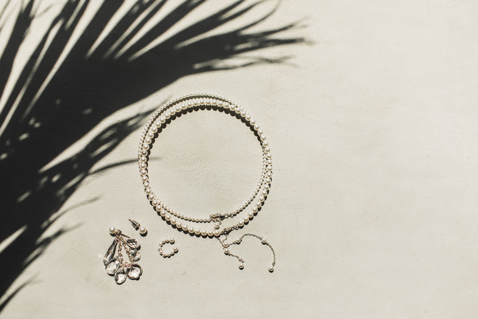 Top view of woman jewelry accessories, pearl necklace and earrings with precious stones