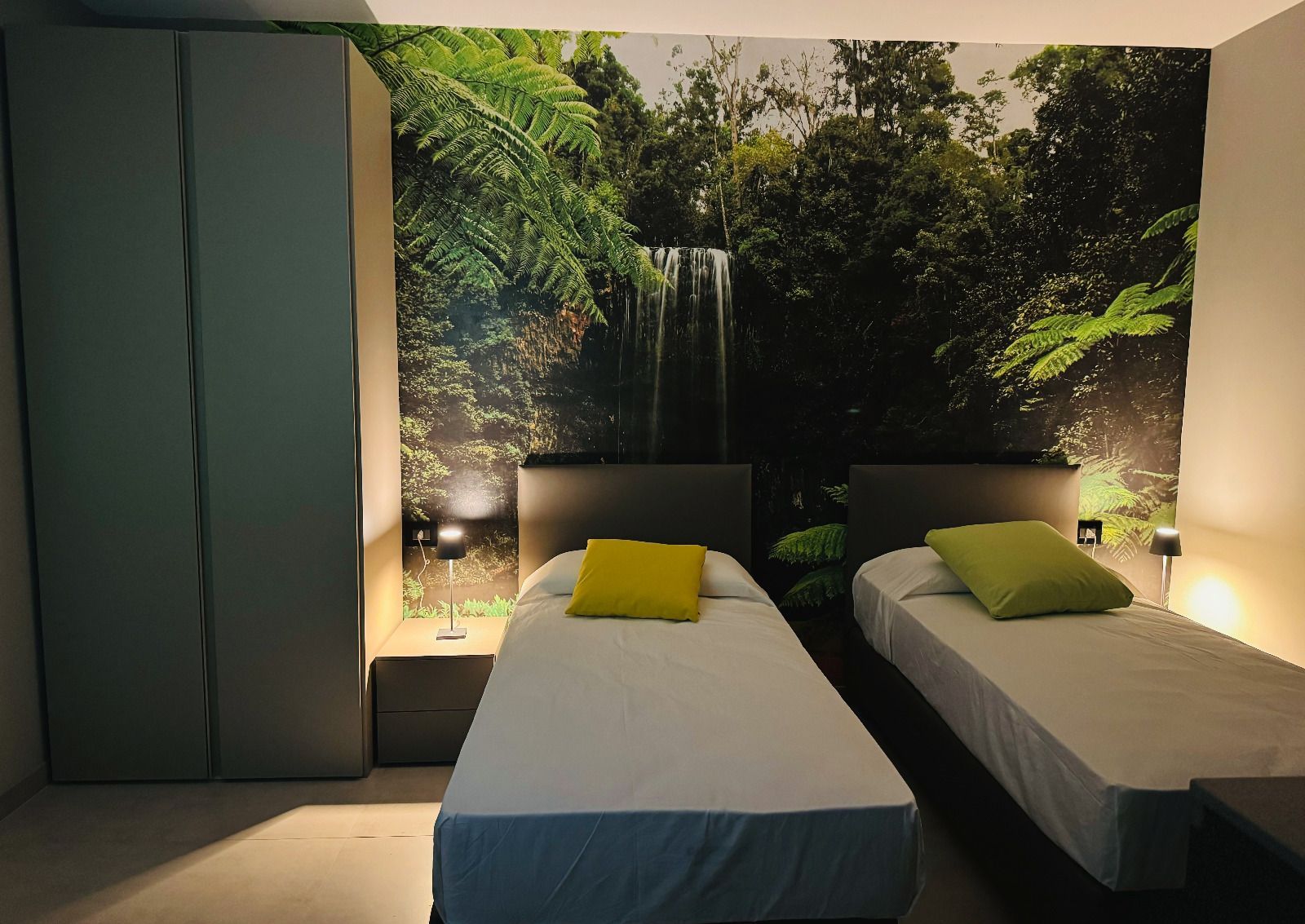 una camera da letto con due letti e una cascata sullo sfondo