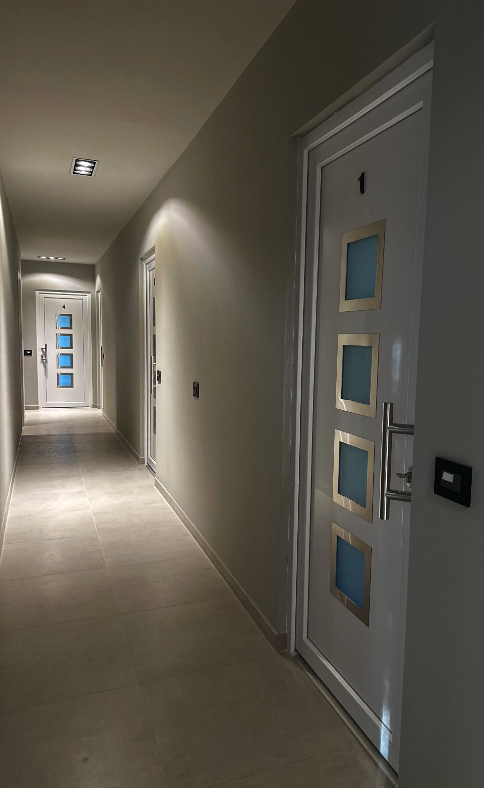 un lungo corridoio con porte bianche e azzurre