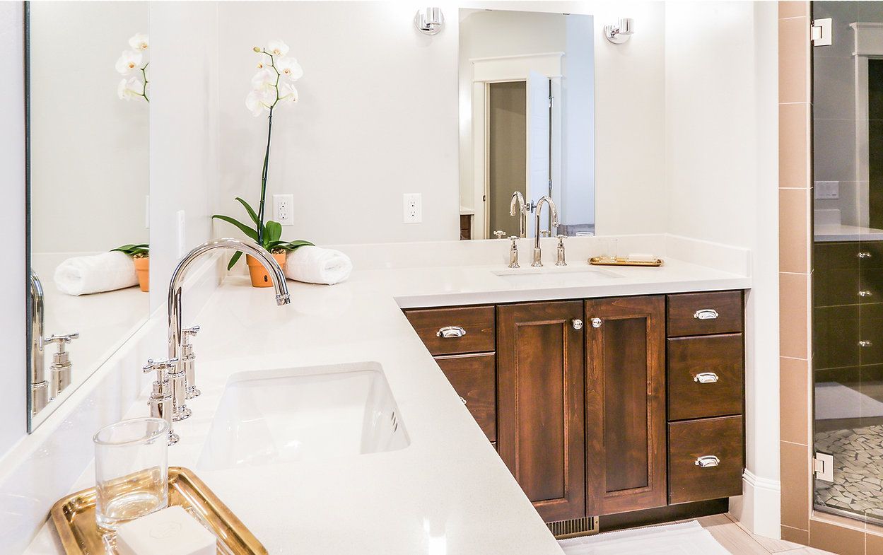 Bathroom with white countertop, dark wood cabinets, and chrome fixtures.