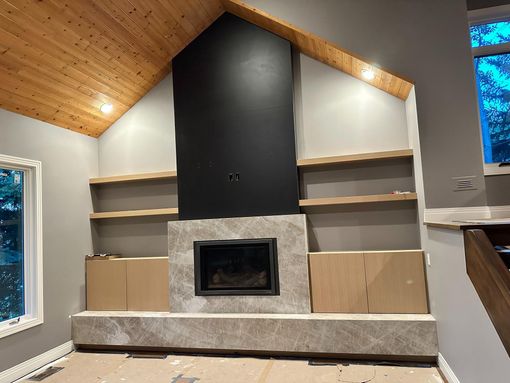 Reception desk with computer and chair, brown and gray colors, artwork on wall.