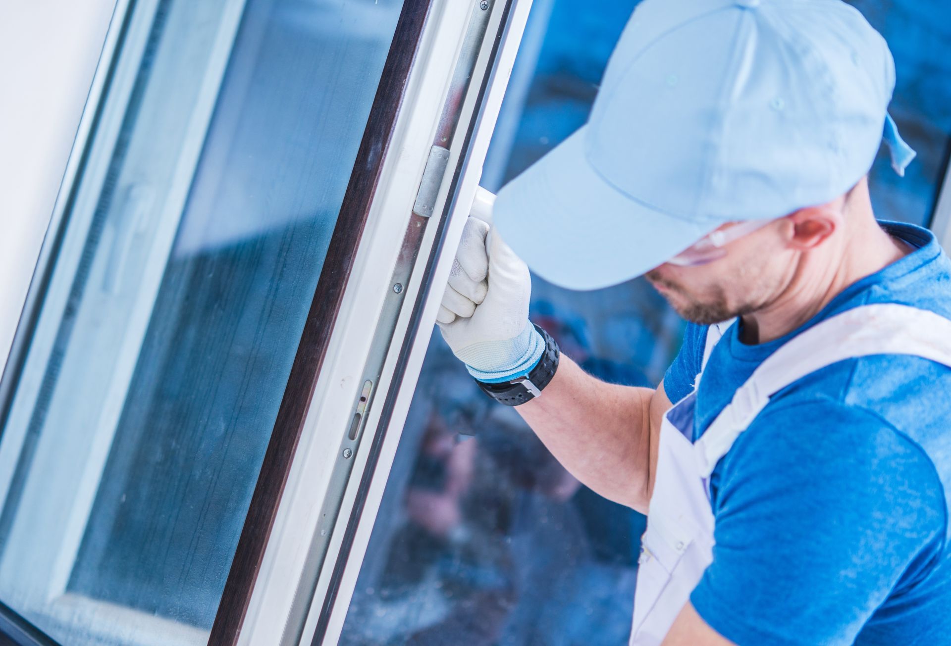 Skilled worker carefully installing a new plastic PVC window in a building, ensuring a precise fit and sealing for energy efficiency.