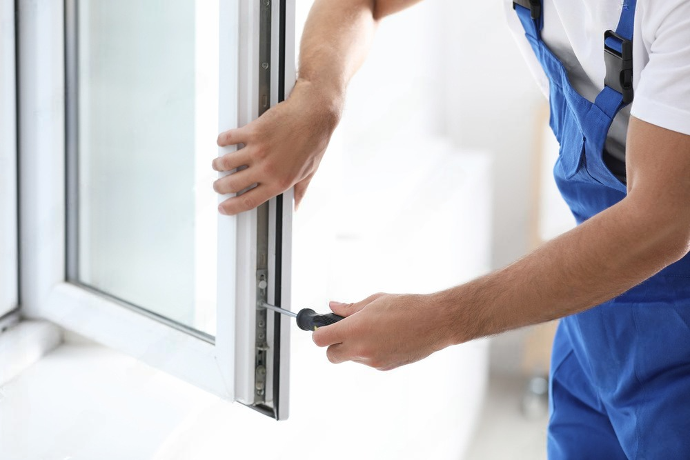 Professional window installation in progress, with a skilled technician securing the new window frame into the wall, ensuring a tight seal for energy efficiency and aesthetic appeal.