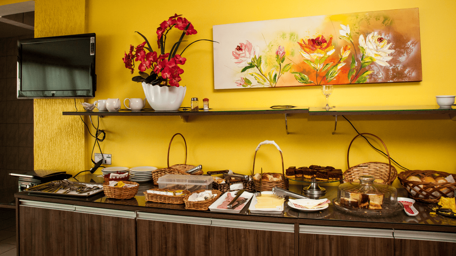 Um bufê com uma pintura de flores na parede acima dele