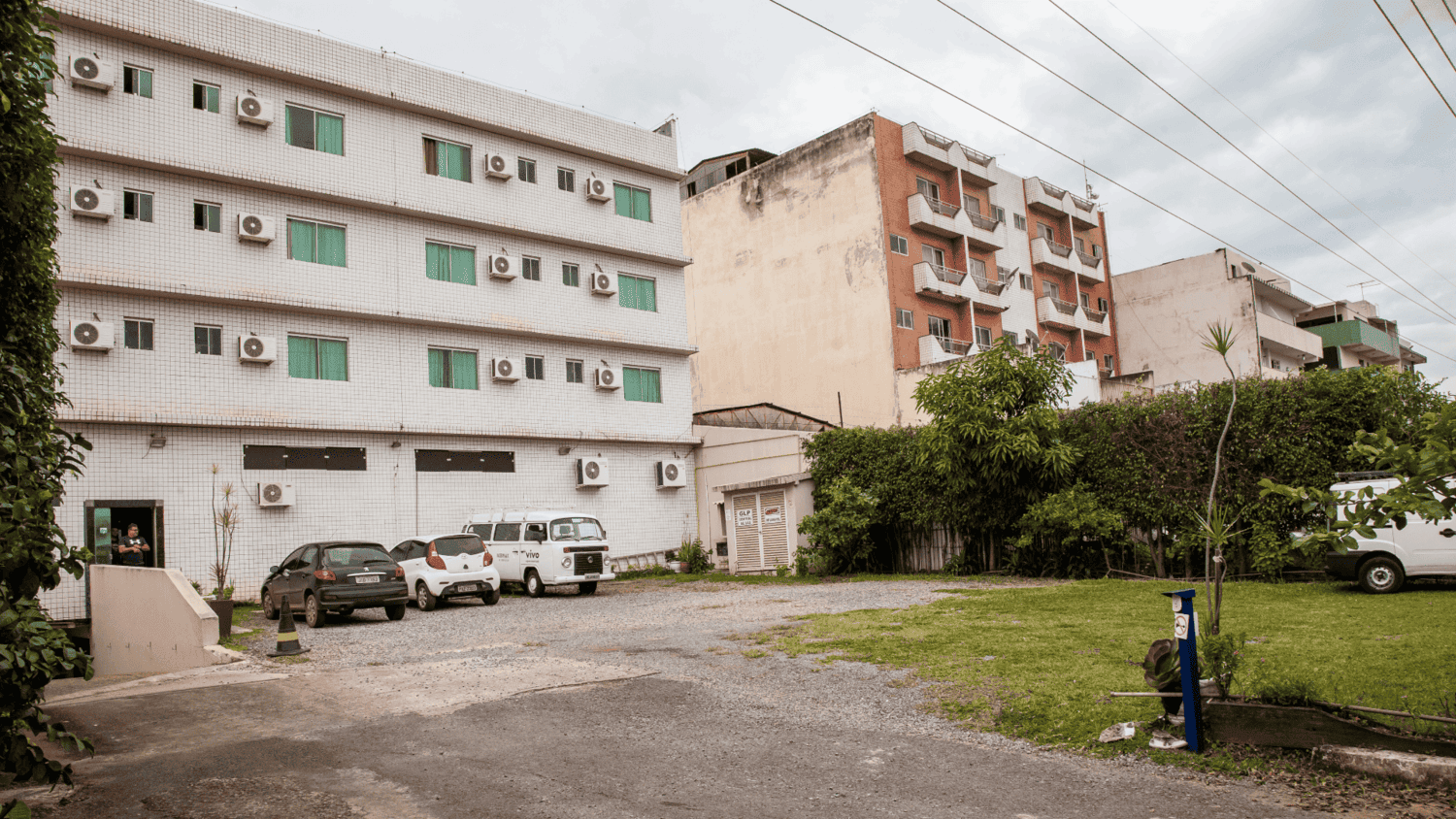 Um estacionamento com carros estacionados em frente a um grande edifício.