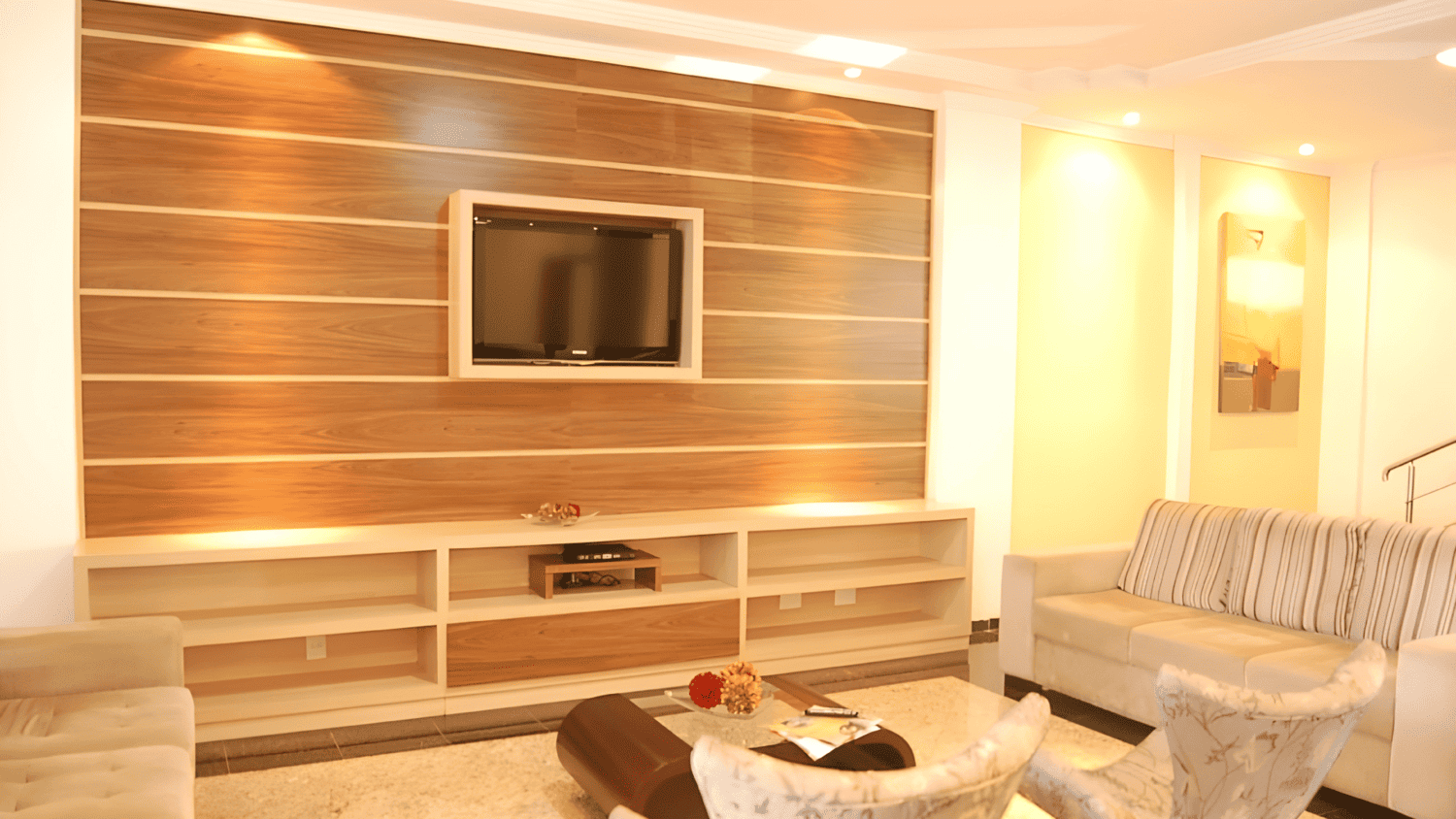 Uma sala de estar com um sofá e uma televisão na parede