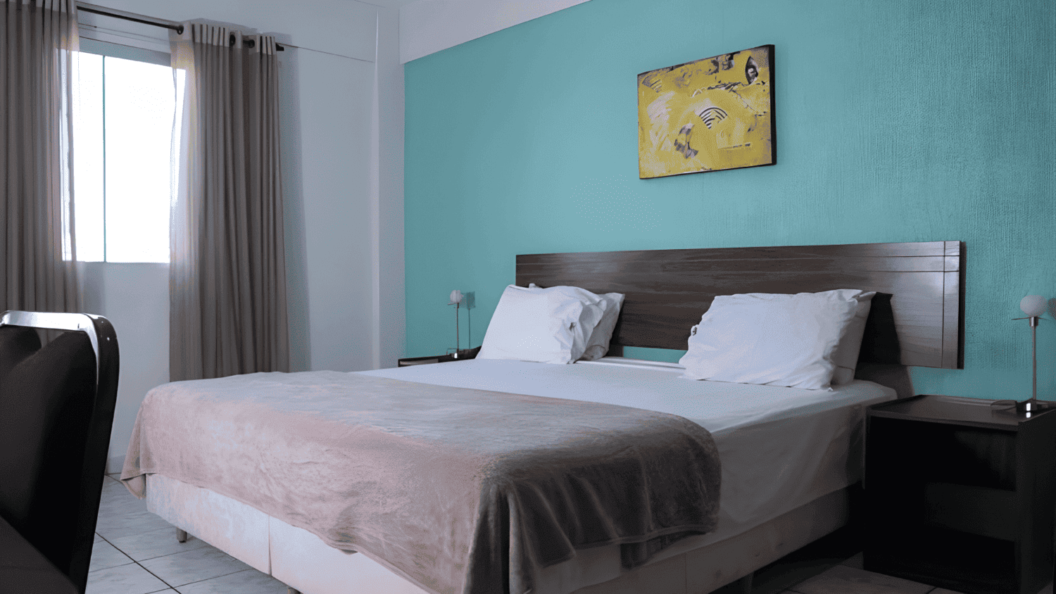 Um quarto de hotel com uma cama grande e uma parede azul.