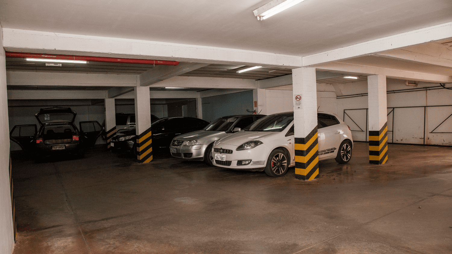 Uma fileira de carros está estacionada em uma garagem.