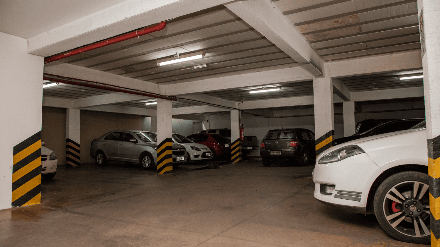 Uma fileira de carros está estacionada em uma garagem.