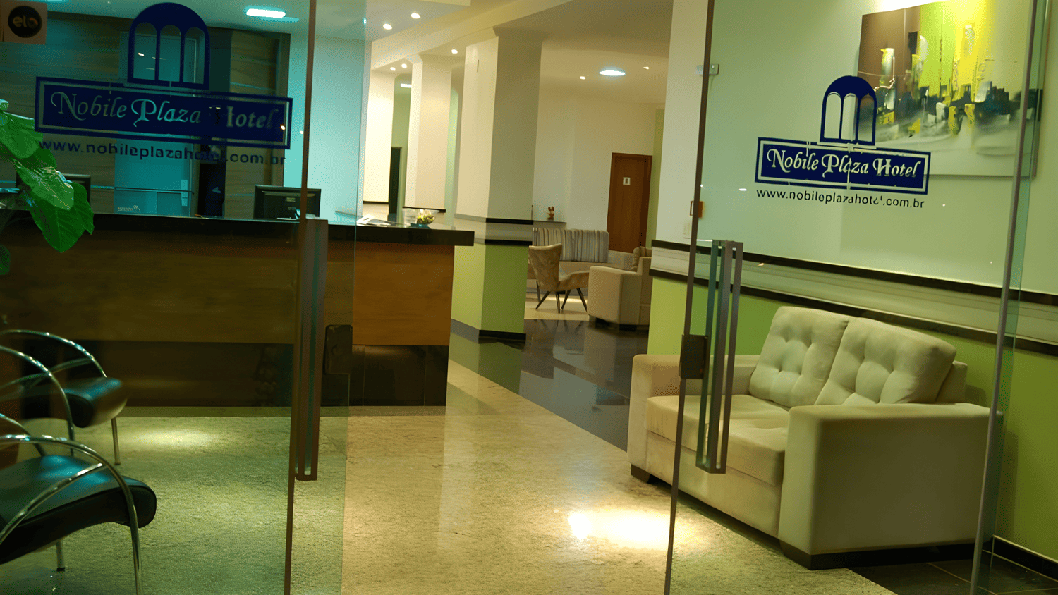 Um saguão de hotel com um sofá e cadeiras