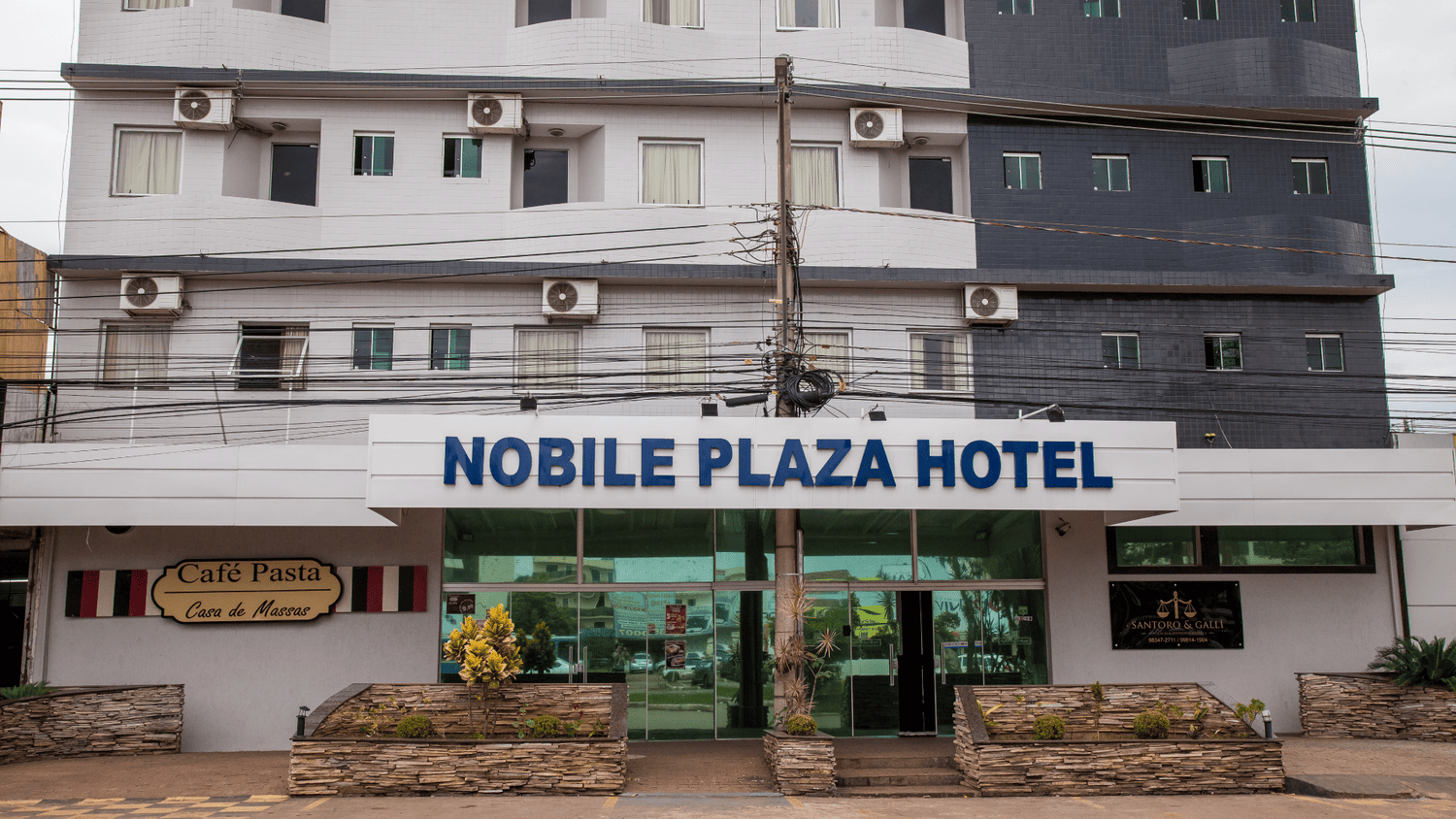 O hotel noble plaza é um edifício grande com muitas janelas
