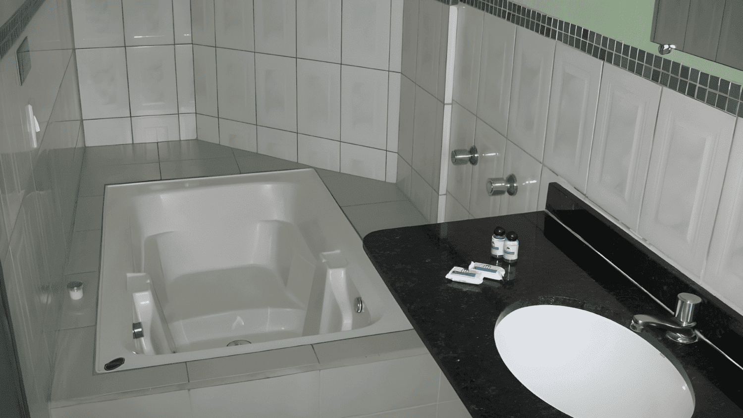 Um banheiro com banheira de hidromassagem e pia