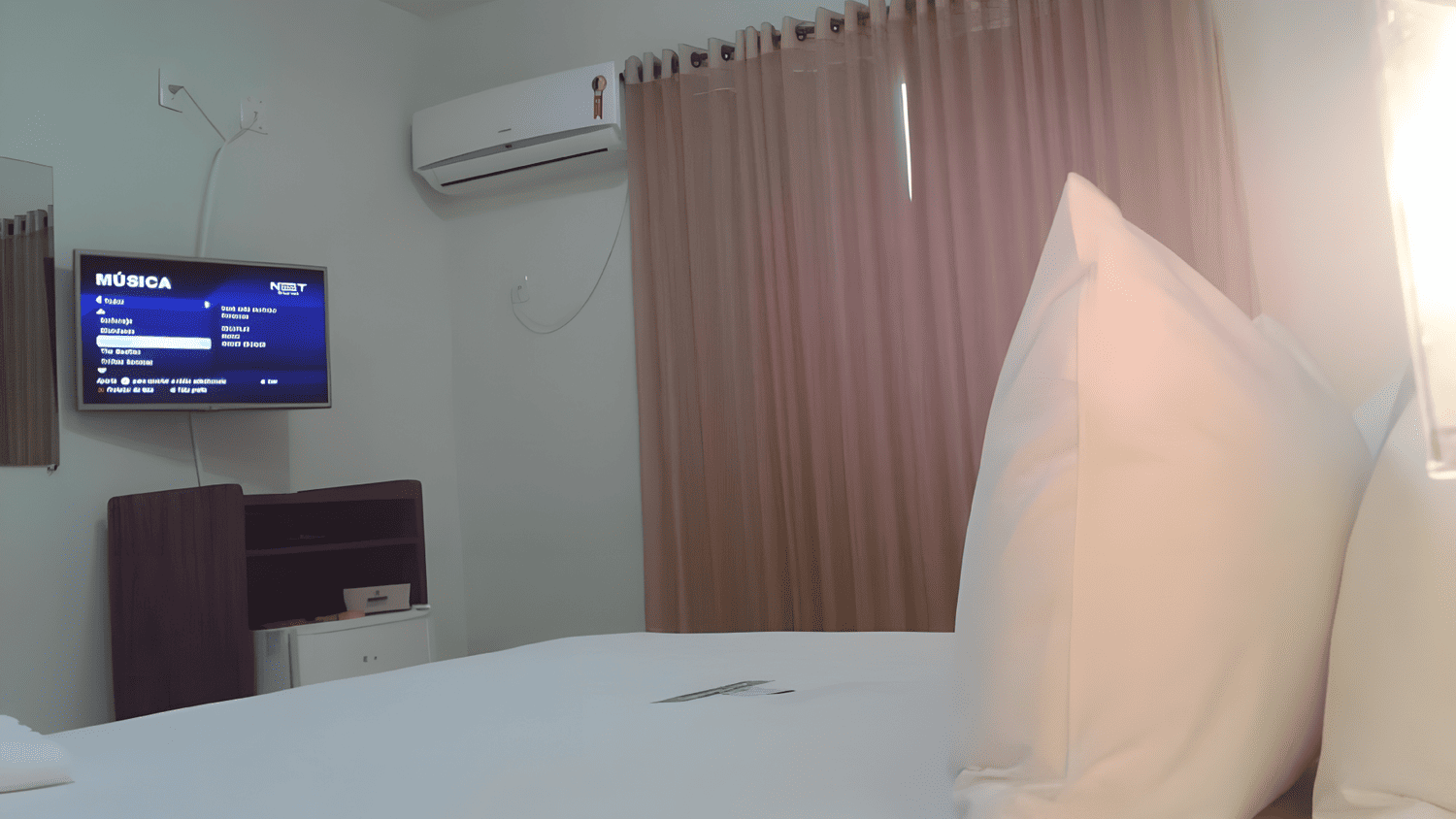 Um quarto de hotel com uma cama e uma TV de tela plana