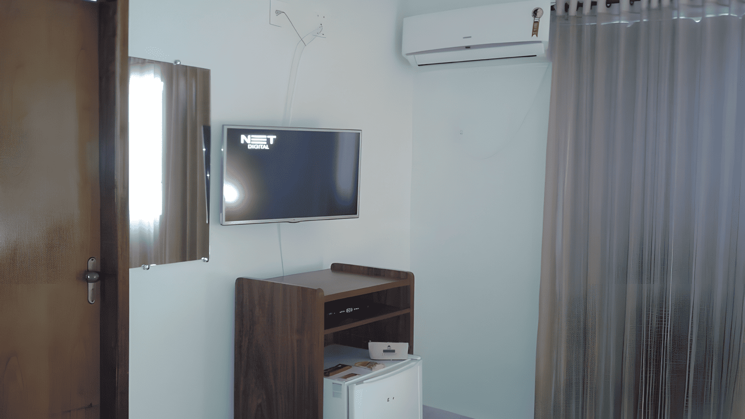 Uma sala com uma TV de tela plana na parede