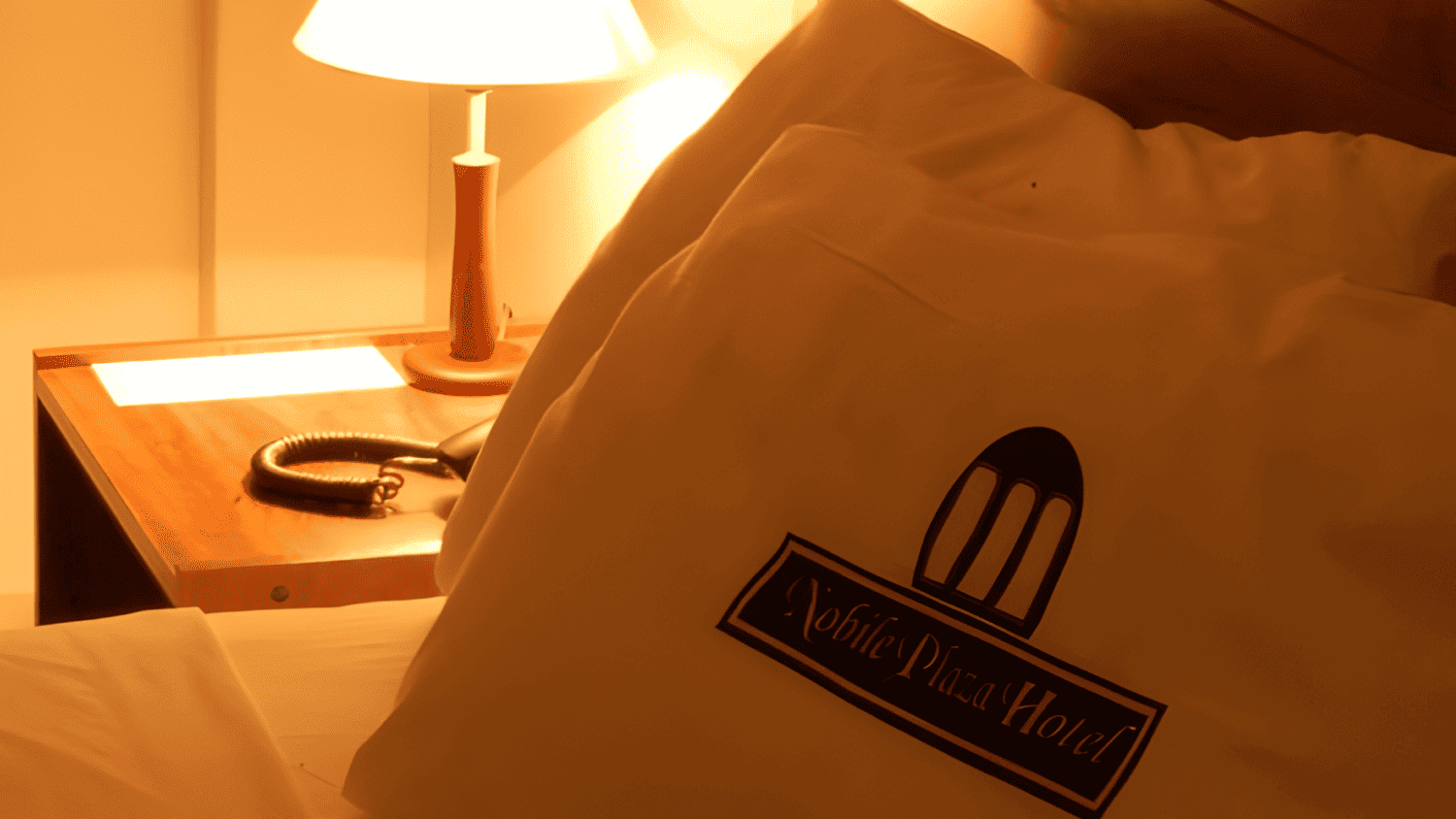 Uma cama com um travesseiro que diz hotel white plaza