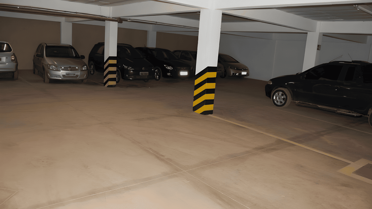 Muitos carros estão estacionados em uma garagem