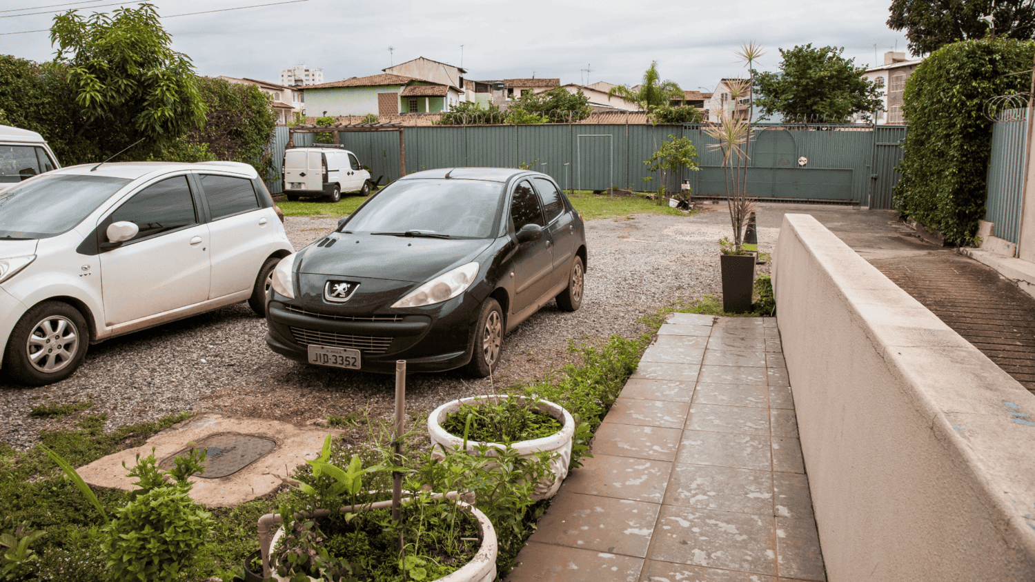 Um carro preto está estacionado ao lado de um carro branco em um estacionamento.