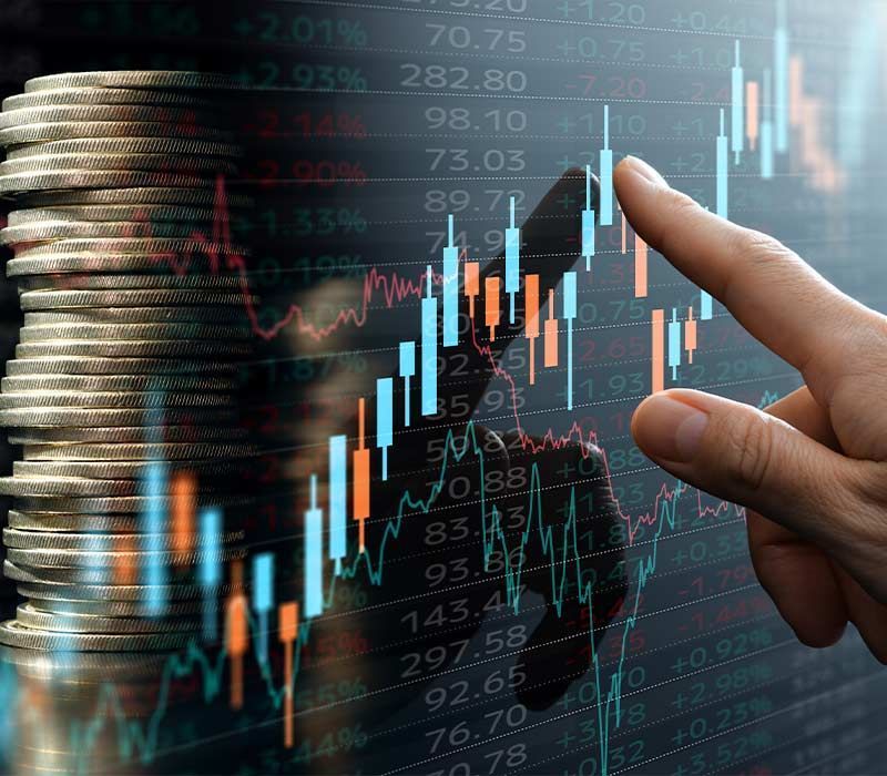 Hand touching a stock chart overlaid on a stack of coins, indicating financial analysis.