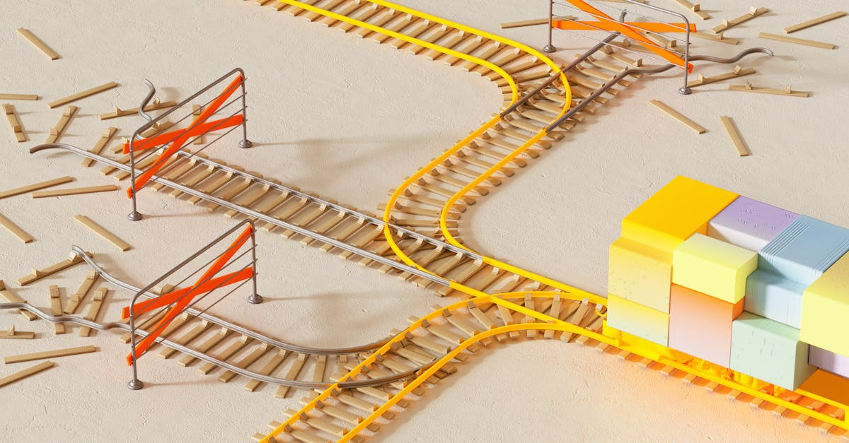 Toy train with colorful blocks traveling on yellow tracks with two intersecting paths and orange barricades.