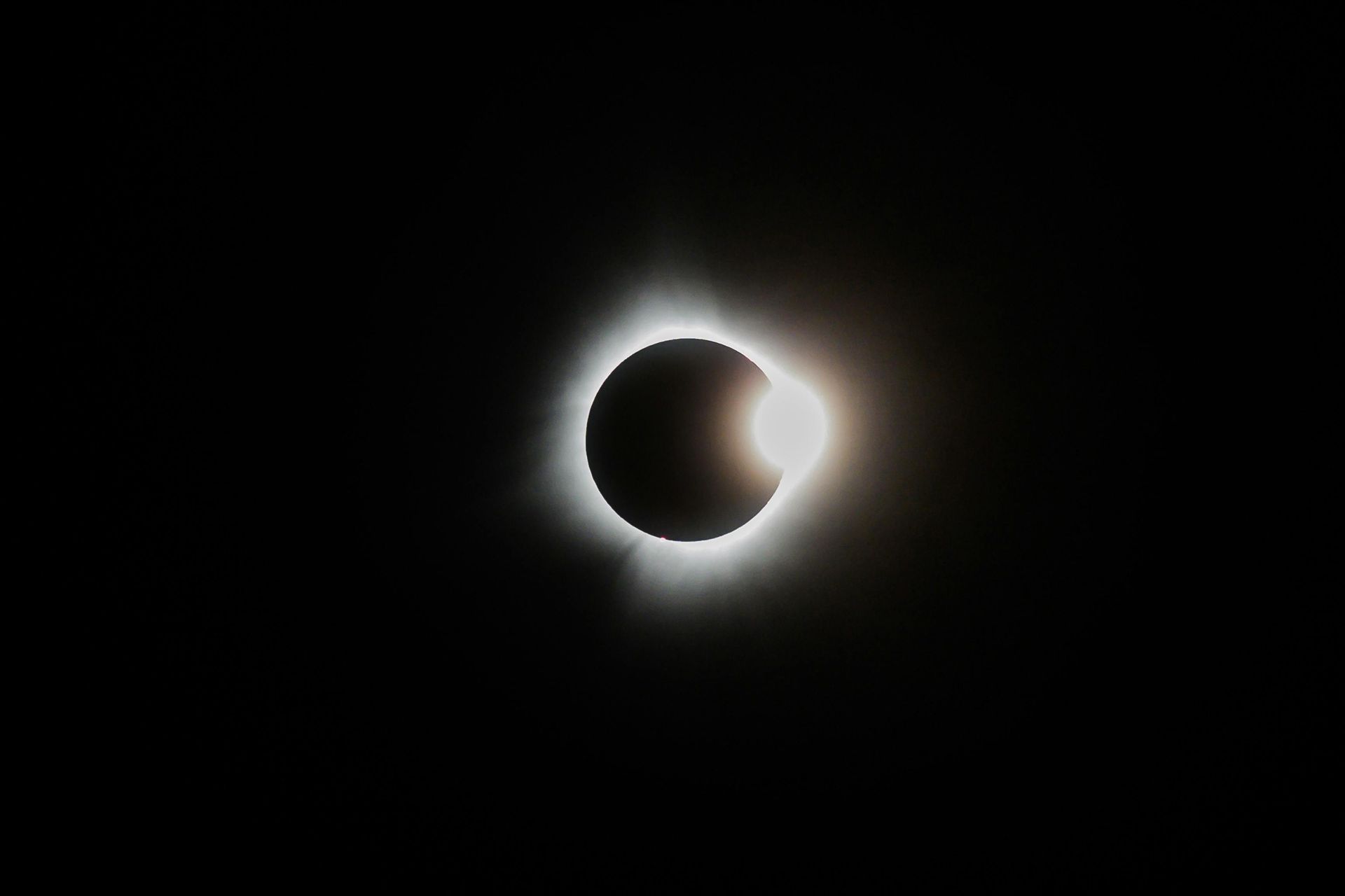 Total solar eclipse: Black disc of the moon against the sun's corona, a bright ring.