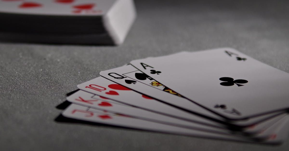 Playing cards spread out with the top of a deck in the background.
