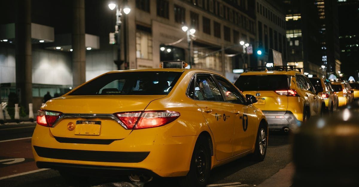 Yellow taxis in a nighttime city street, taillights glowing.
