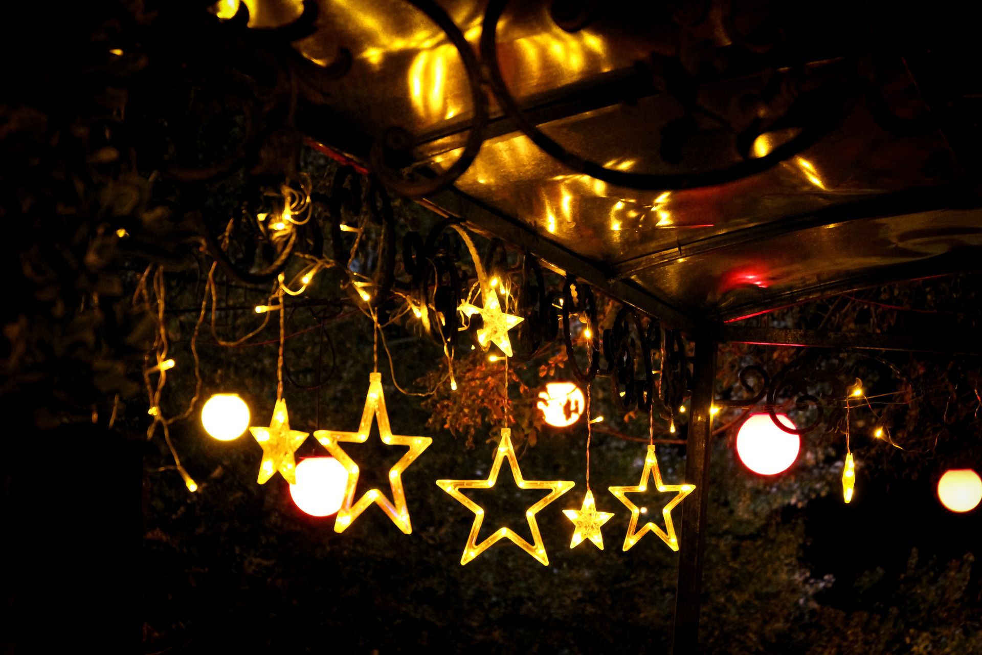 String lights with illuminated stars and orbs hang from a dark ceiling.
