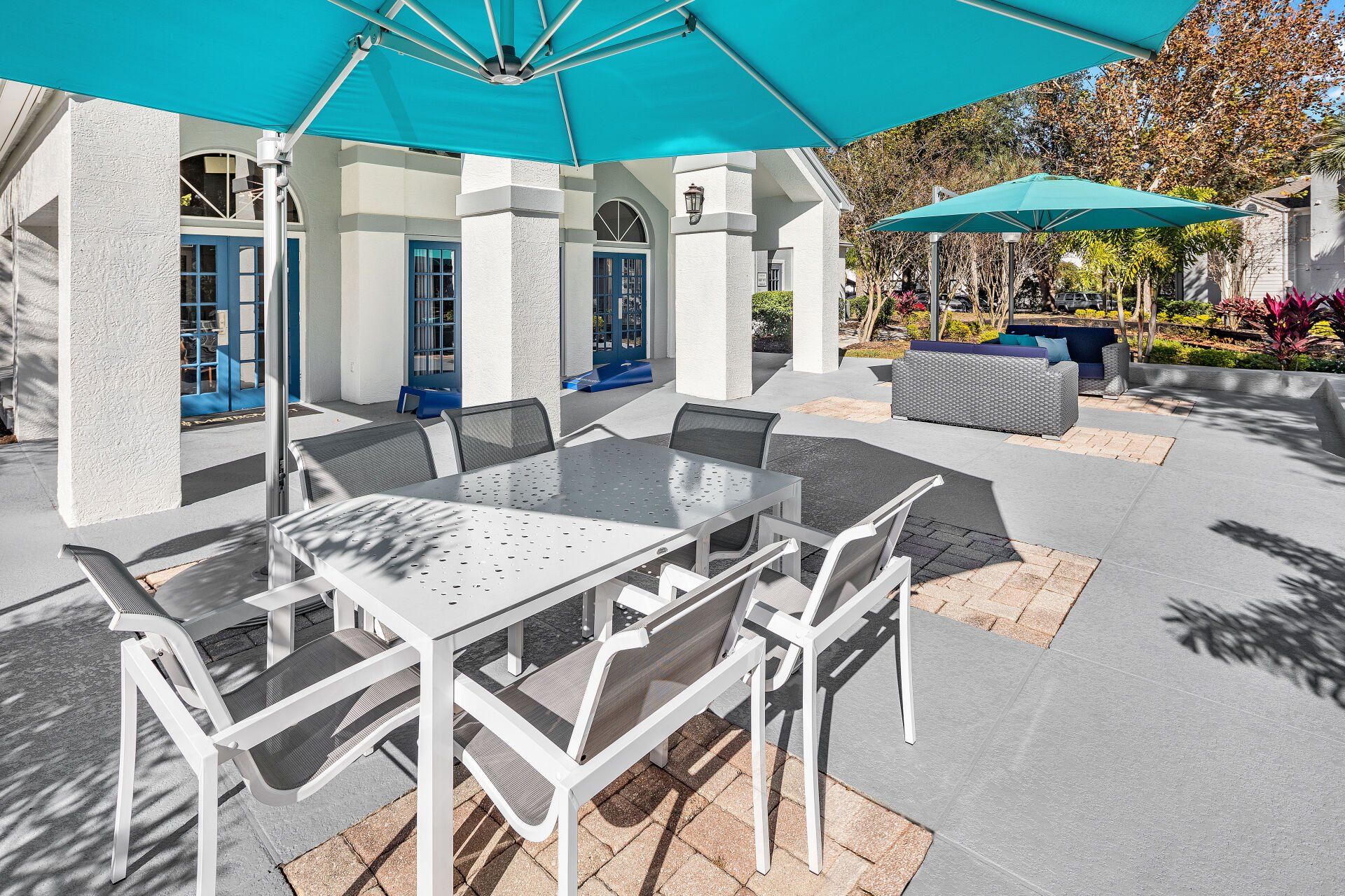A patio with a table and chairs under an umbrella.