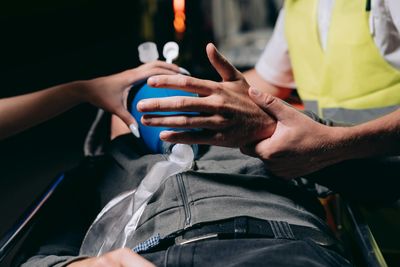 A man is laying on a stretcher with an oxygen mask on his face.