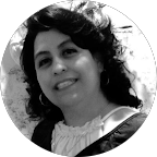 Woman smiling, in a circular frame. Dark hair, light-colored blouse, and visible jewelry.